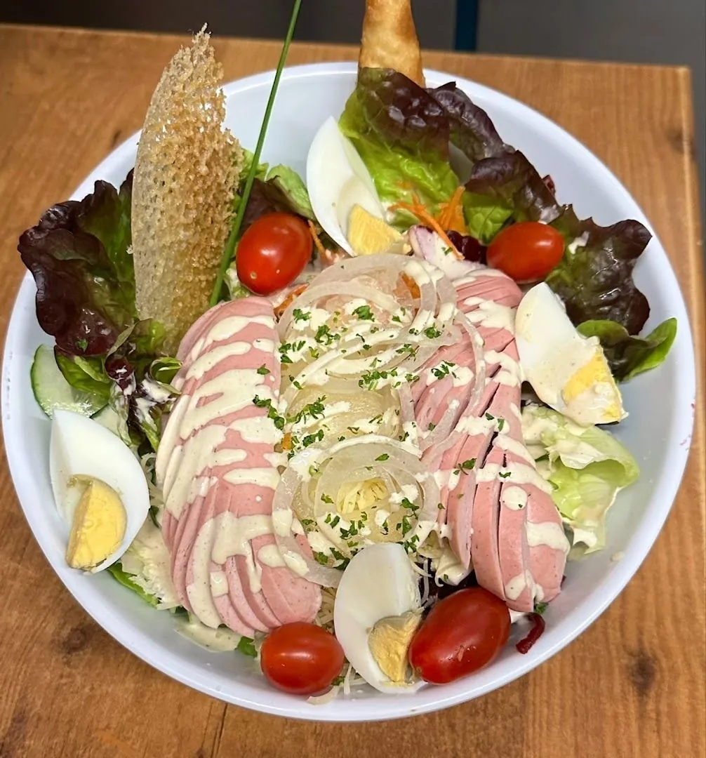 Une grande salade composée servie en salle