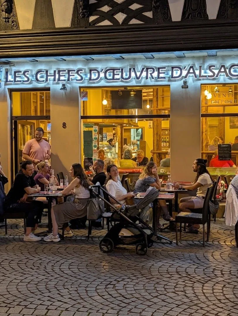 La terrasse le soir, sous l'enseigne éclairée
